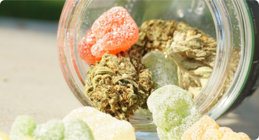 Hemp Bud and Edibles in a glass jar spilling out.