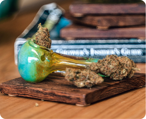 Image of a glass pipe with bud in it sitting on a coffee table.